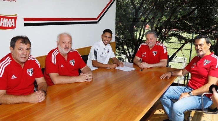 Foto: Divulgação/São Paulo FC - Momento em que o lateral assinou seu contrato. Foto: Divulgação/São Paulo FC - Momento em que o lateral assinou seu contrato.