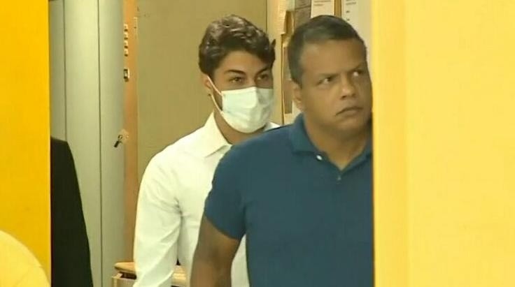 Marcinho (de máscara) deixa delegacia após o depoimento – Foto: Reprodução