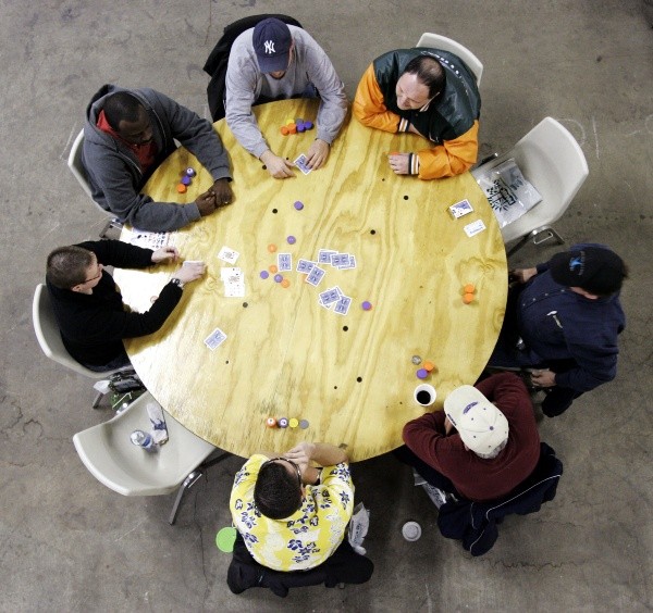 PARK CITY, KS - FEBRUARY 12: A table of seven players compete in a game of poker during the first day of the Park City Poker Round Up in Park City, Kansas on Febuary 12, 2005 at the Kansas Coliseum Pavilion. The event, billed as the largest amateur poker tournament ever, is expected to draw as many as 17, 500 people from around the country over the 8 days in three months of competition. It is expected to take 30,000 poker chips, 600 decks of cards and around 300 tables to accommodate the crowds. (Photo by Larry W. Smith/Getty Images)-Not Released (NR)