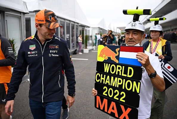 Max com uma placa comemorativa de campeão no paddock.      Créditos: Clive Mason/Getty Images
